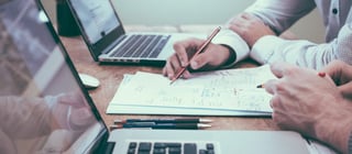 pessoas trabalhando em projeto em bim em frente a computadores e papel com informações